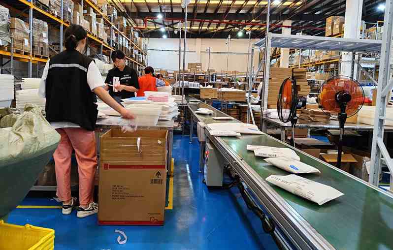 Staff working at Runtoagent warehouse with packages on conveyor belt, showing professional logistics operations