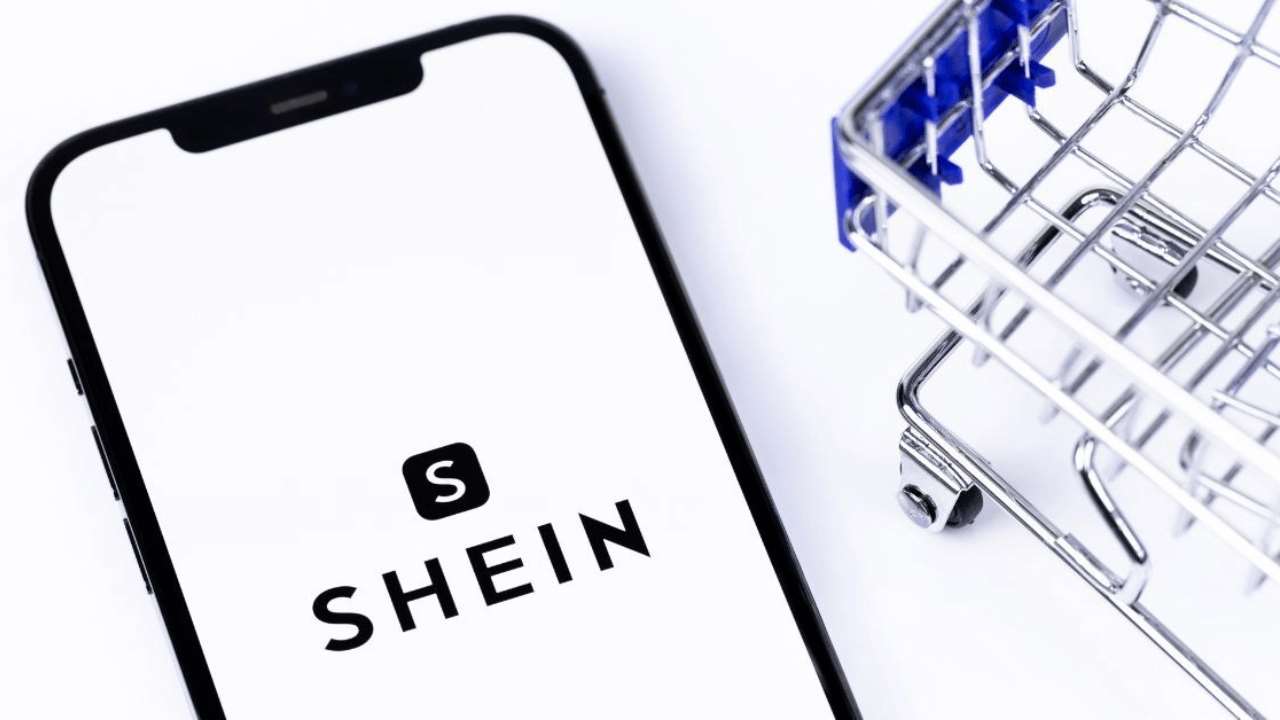 Shein logo on smartphone with mini shopping cart — a symbolic image representing the dominance of Shein in fashion eCommerce and why sellers are searching for similar sites like Shein.