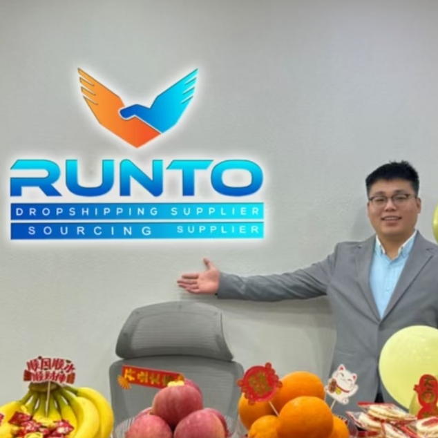 A person standing in front of a Runto company logo, showcasing a variety of fruits on a table. The setting reflects a professional office environment focused on dropshipping and sourcing services.